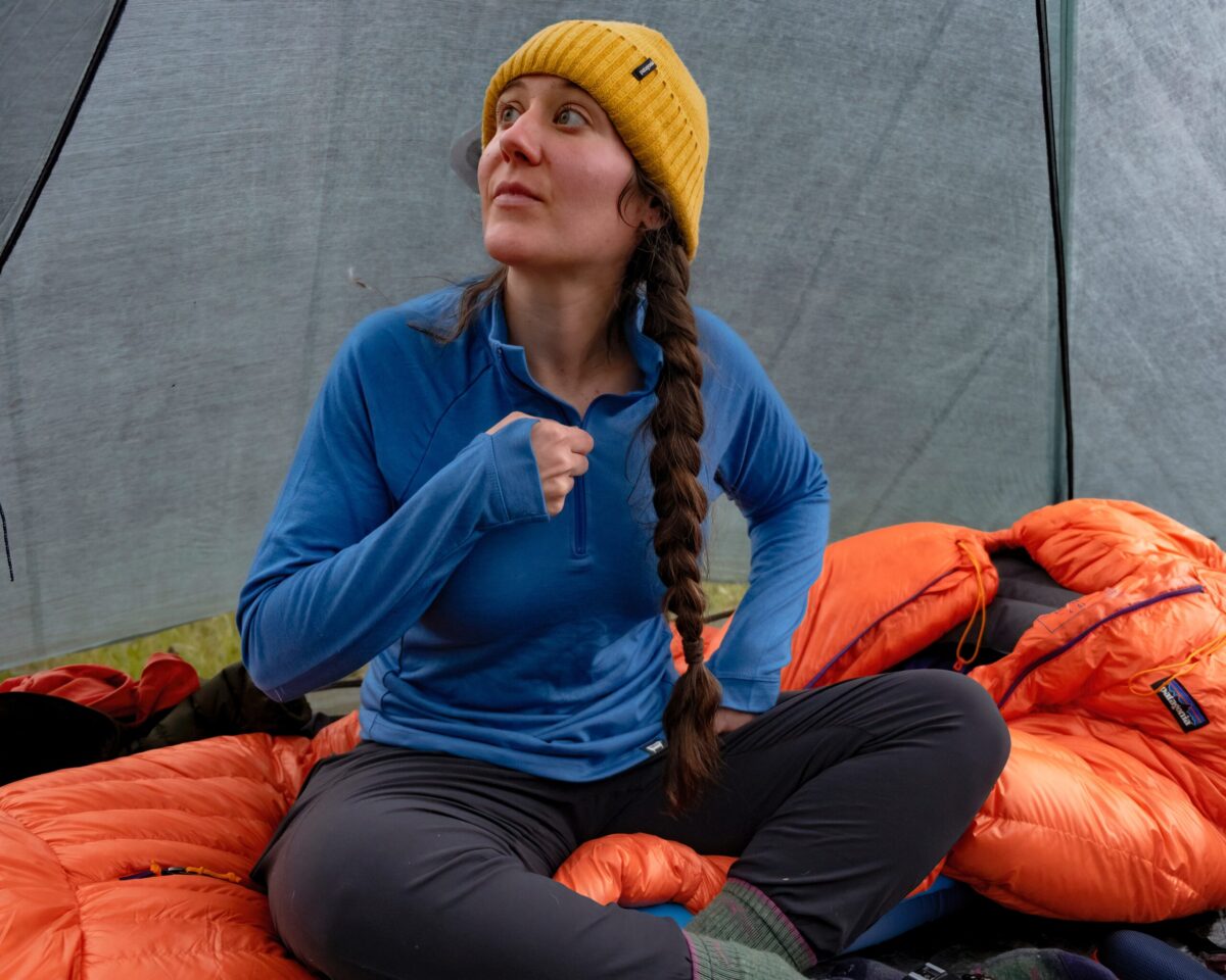 A woman confidently cozy in her tent.